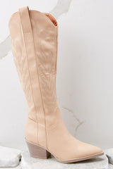 These nude colored boots feature a pointed toe, a half-length side zipper, a faux leather finish with stitched detailing throughout, and a non-skid rubber sole.