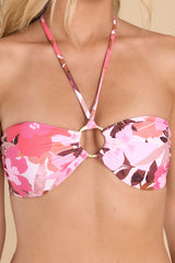 This pink bandeau bathing suit top features a self-tie around the neck, a gold hoop detail, and a clasp clip in the back.