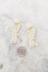 Top view of these pearl earrings that feature pearl detailing throughout that spells 