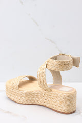 Inner-side view of these shoes that feature an raffia style strap across the top of the foot, a raffia-style strap that wraps around the ankle with a gold hardware closure, light padding for added comfort, and an espadrille platform design.