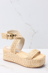 These natural colored shoes feature an raffia style strap across the top of the foot, a raffia-style strap that wraps around the ankle with a gold hardware closure, light padding for added comfort, and an espadrille platform design. 