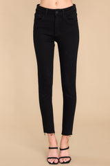 Front view of these jeans that feature a front zipper, front and back functional pockets, and a raw hemline at the ankle.