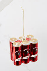 Top view of this ornament that features six red cans with white and gold accents and glitter detailing.