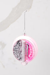 This pink ornament features a round can shape that says 