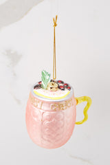 This pink ornament features a drink-like design with glitter writing across. 