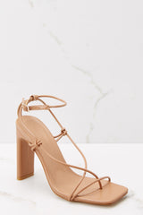 Outer-side view of these heels that feature thin straps that cross over the feet to buckle in at the ankle, a square tow, and thin straight heels.