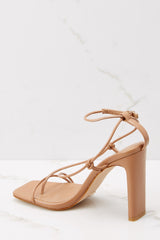 Inner-side view of these heels that feature thin straps that cross over the feet to buckle in at the ankle, a square tow, and thin straight heels.