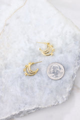 Gold huggie hoop earrings compared to quarter for actual size. Earrings measure .75