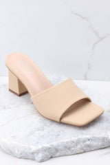 Full view of these heels that feature a square toe, a thick strap across the top of the foot, a block heel, a suede feel, and a slip-on design.