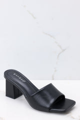 Outer-side view of these heels that feature a square toe, a thick strap across the top of the foot, a square heel, a faux-leather finish, and a slip-on design.