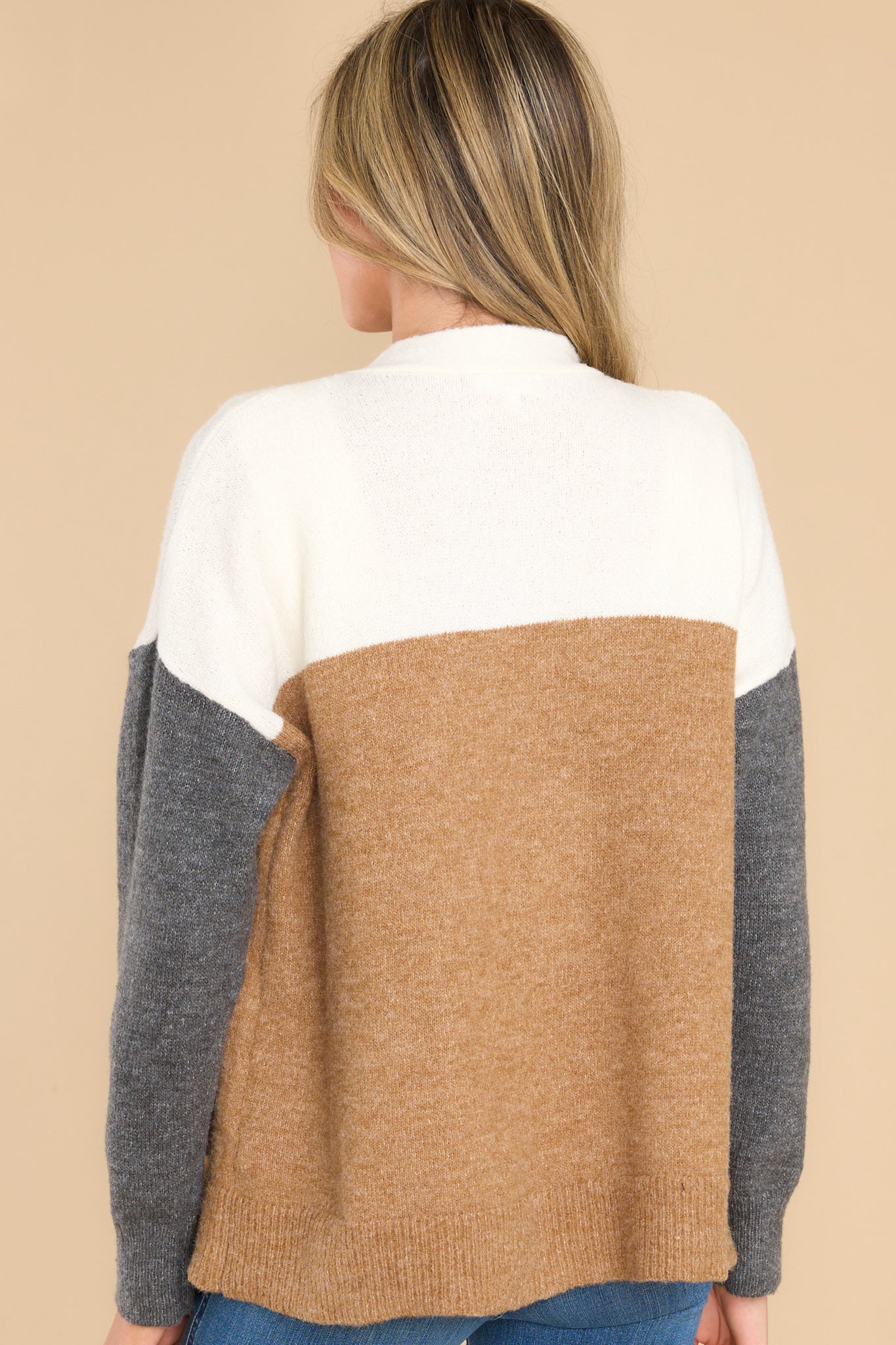 Back view of this cardigan that features a v-neckline with functional buttons down the front, functional pockets, and a soft, wooly feel.