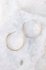 Top view of these hoop earrings that feature a gold finish and a secure post backing.