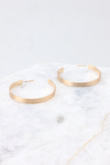 Side view of these hoop earrings that feature a gold finish and a secure post backing.
