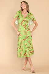 This green dress features a v-neckline, flutter sleeves, a zipper down the side, and a flowy tiered skirt.