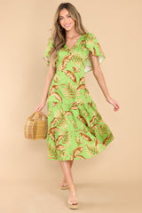 Front view of this dress that features a v-neckline, flutter sleeves, a zipper down the side, and a flowy tiered skirt.