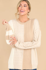 Front view of this cable knit sweater that features a scoop neckline, a color block design, and ribbed collar and cuffs.