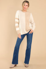 Full body view of this cable knit sweater that features a scoop neckline, a color block design, and ribbed collar and cuffs.