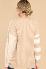 Back view of this cable knit sweater that features a scoop neckline, a color block design, and ribbed collar and cuffs.