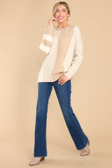Full body view of this cable knit sweater that features a ribbed collar and cuffs.
