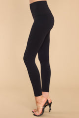 Side view of these leggings that feature a double layered high rise waistband, seamless detailing throughout, and contains stretch.