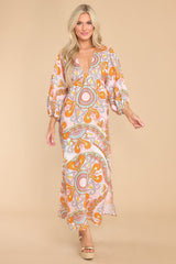 This multi-colored print dress features a v-neckline, puff sleeves with elastic cuffs, and slits on both sides.
