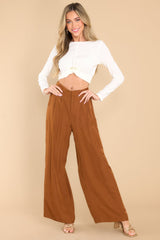 Full body view of these pants that feature a high rise, a zipper and hook and eye closure, an elastic band at the back of the waist.