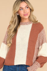 Front view of this sweater that features a round neckline, long sleeves with stretchy cuffs, a chunky knit texture, and a striped colorblock design.