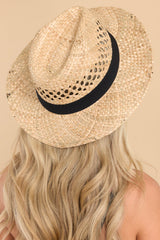 This khaki hat features a woven material, black ribbon trim, and offers UV protection. 