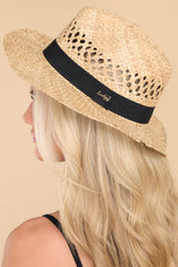Side view of this hat that features a woven material, black ribbon trim, and offers UV protection. 