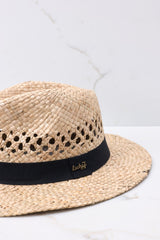 Close up view of  this hat that features a woven material, black ribbon trim, and offers UV protection.