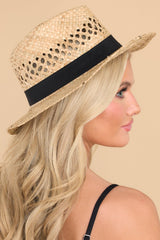 Angled side view of  this hat that features a woven material, black ribbon trim, and offers UV protection.