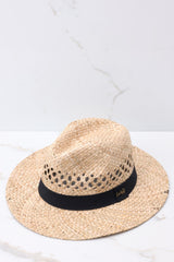 Angled top view of  this hat that features a woven material, black ribbon trim, and offers UV protection.