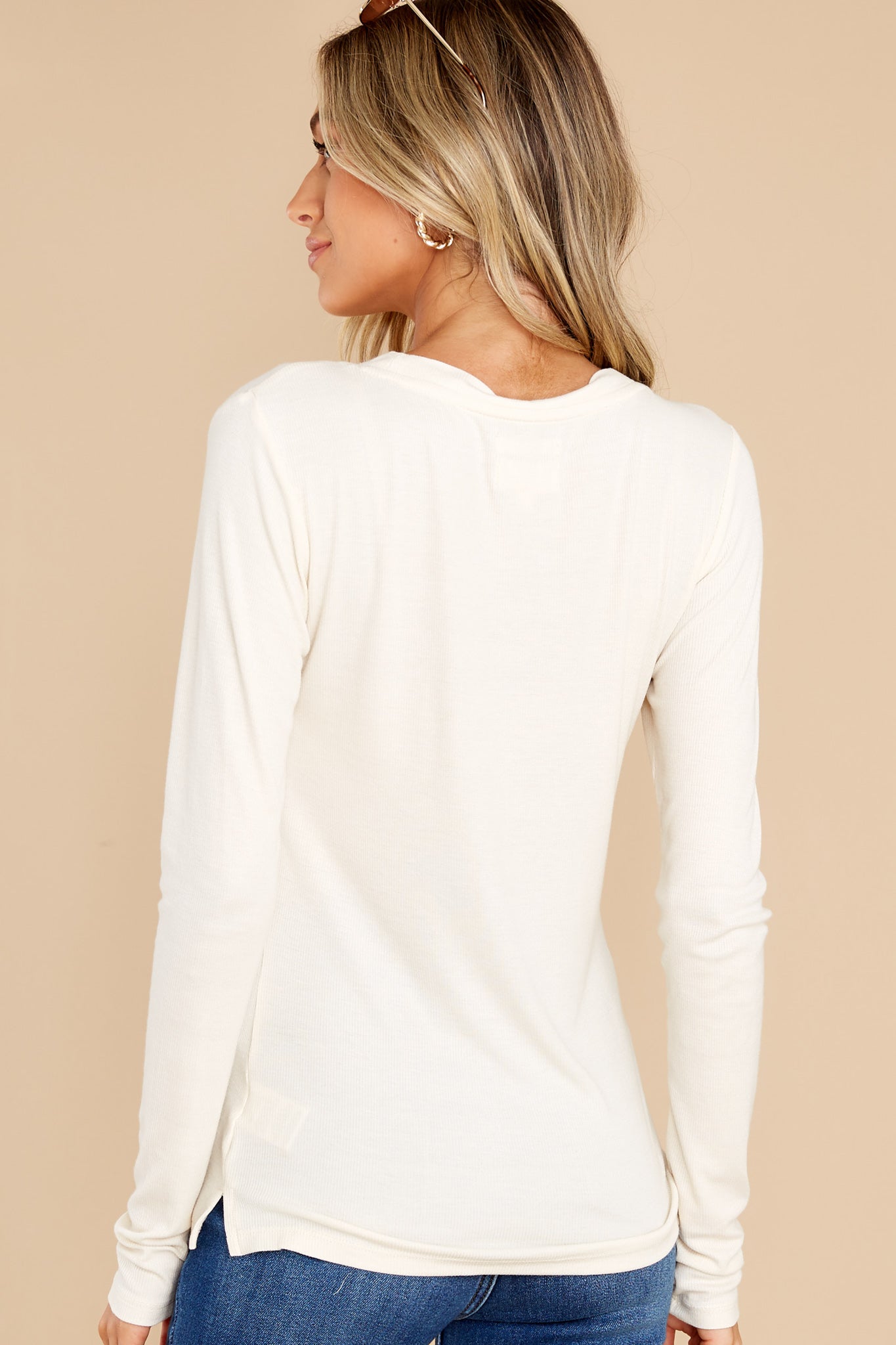 Back view of this top that features a relaxed fit with a v-neckline, long sleeves, and buttons down the bust area.