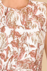 Close up view of this dress that features a round neckline and a leaf like pattern.