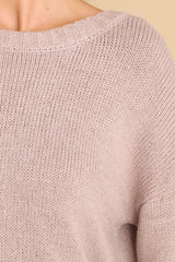 Close up view of this sweater that features a scoop neckline, a low v opening on the back, and a opening on the lower back.