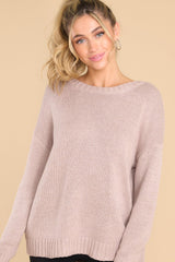This light brown sweater features a scoop neckline, a low v opening on the back, and a opening on the lower back. 