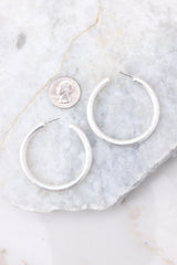 Silver Hoop Earrings compared to quarter for actual size.  Earrings measure 2