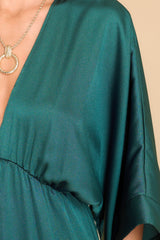 Close up view of this dress that features a plunging v-neckline, dolman sleeves, and an elastic waistband.