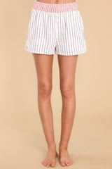 Close up view of these shorts that feature an elastic waistband, two functional pockets, three decorative buttons, 1