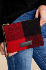 This red and black clutch features a leather strap with zipper closure and real wool fabric.