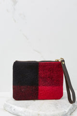 Back view of this clutch that features a leather strap with zipper closure and real wool fabric.