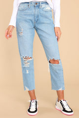 These light wash jeans feature a high waist, distressed details, raw hems, 5-pocket styling with functional pockets, belt loops, and a zipper fly.