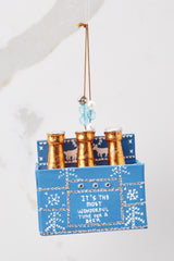 Front view of this ornament that features gold covered bottle tops in a blue box that says 