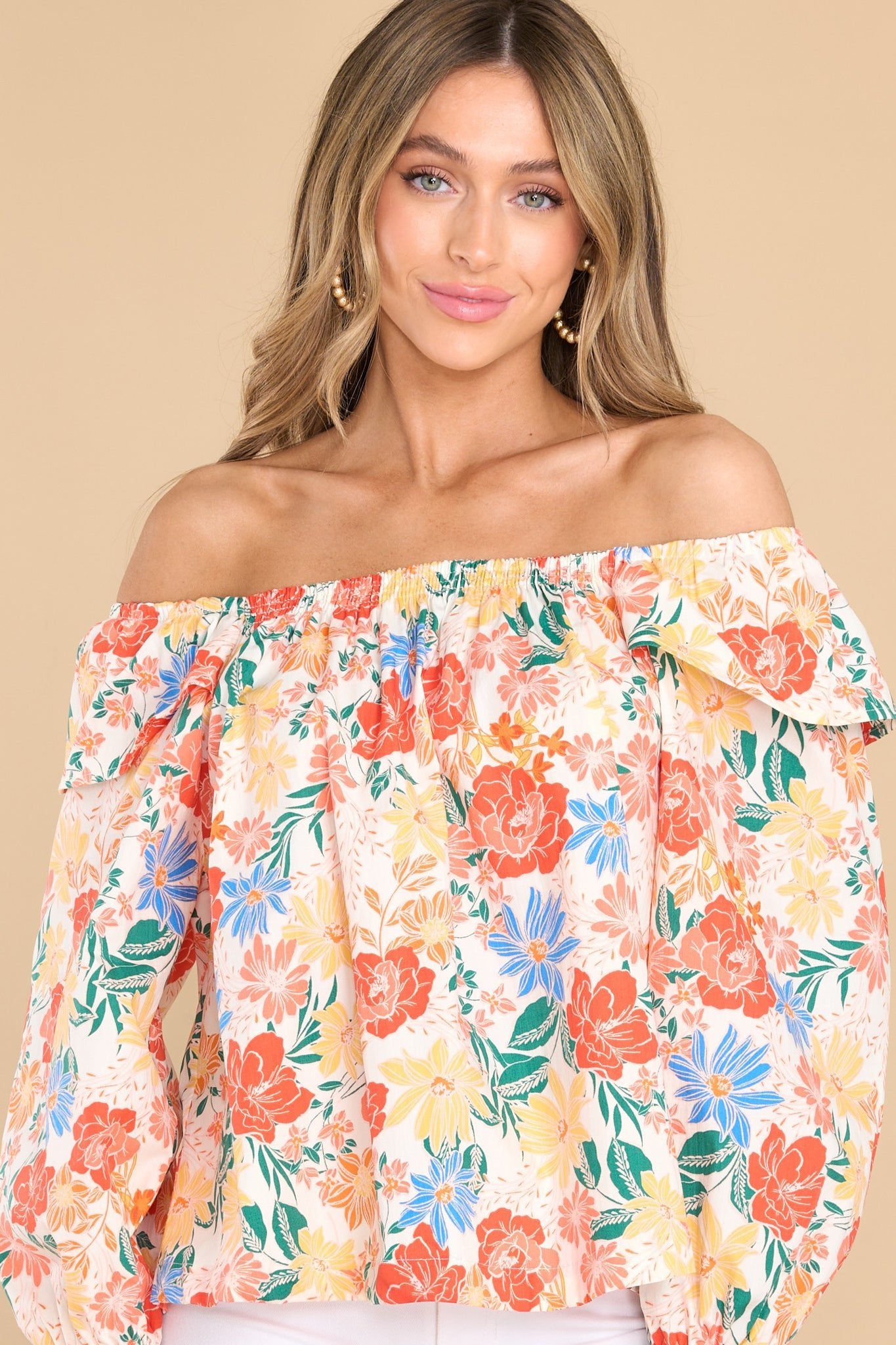 This ivory floral top features a stretchy scoop neckline, an optional off-the shoulder style, ruffle detailing in the shoulders, and long sleeves with elastic cuffs.