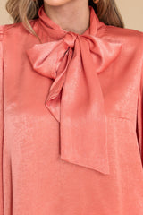 Close up view of this top that features a high neckline with an adjustable self tie.