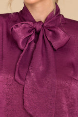 Close up view of this top that features a high neckline with an adjustable self tie.