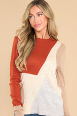 This multi-colored sweater features a crew neckline, ribbed cuffs and hem, a multi-colored geometric pattern, and a soft knit material.