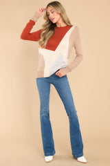 Full body view of this sweater that showcases the color-blocked pattern in shades of grey, cream, tan, and rust.