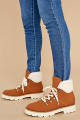 Close up view of these boots that feature faux fur around the ankle, a chunky sole and laces up the front.