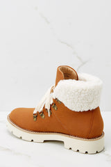 Inner-side view of these boots that feature faux fur around the ankle, a chunky sole and laces up the front.